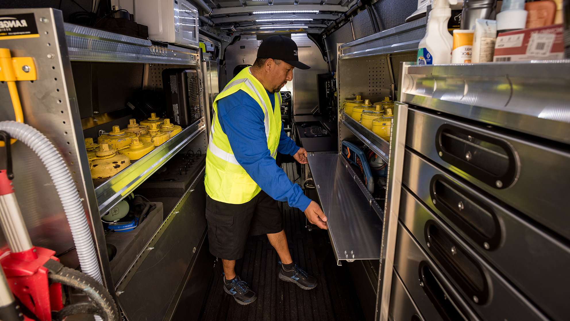 San Jose Water employee looking through the back of his organized truck.